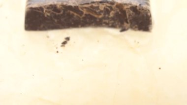 Çerçevede büyük bir parça çikolata ambalaj kağıdı belirir. 