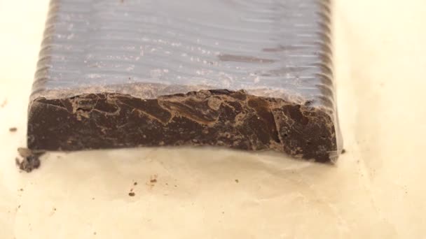 Ein riesiges Stück Schokolade aus Packpapier entfalten — Stockvideo