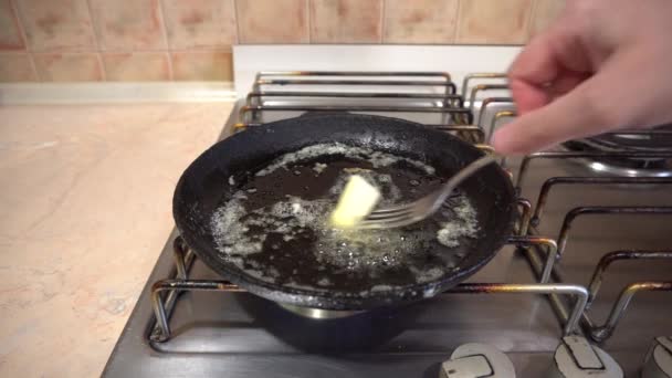 Cuisson des œufs dans une poêle avec du beurre, poêle en fonte sur un poêle à la maison — Video