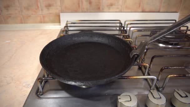 Un homme allume un brûleur à gaz, met une casserole sur la cuisinière et la graisse avec du beurre — Video