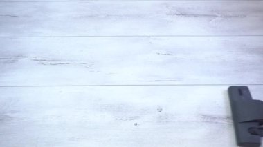 Daire temizliği, gri parke süpürülmesi ve lamine döşeme. Gri lamine döşemeleri süpüren bir adam. Hizmetçinin haftalık temizliği.
