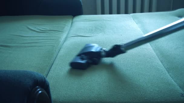 Junge Frau mit Staubsauger beim Putzen des Sofas im Haus. Staub mit dem Staubsauger entfernen — Stockvideo