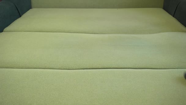 Man handzuiger stof van groene textiel bekleding bank met stofzuiger. Huishoudelijke werkzaamheden — Stockvideo