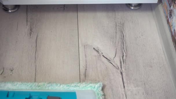 Ember takarít padló felmosó szürke laminált felületen mellett szekrény és a plinth fal. Közelkép — Stock videók