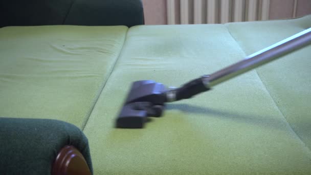 Καθαρισμός άνθρωπος υπηρεσία σκούπισμα του καναπέ, ηλεκτρική σκούπα hoovering πράσινο κρεβάτι ottoman, Σαββατοκύριακο δραστηριότητες καθαρισμού — Αρχείο Βίντεο