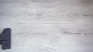 Elektrikli süpürge fırçası gri kaplamalı yüzeydeki tozu emer. Daire temizleme, gri parke süpürücü, döşeme kaplaması, hizmetçi haftalık temizliği.