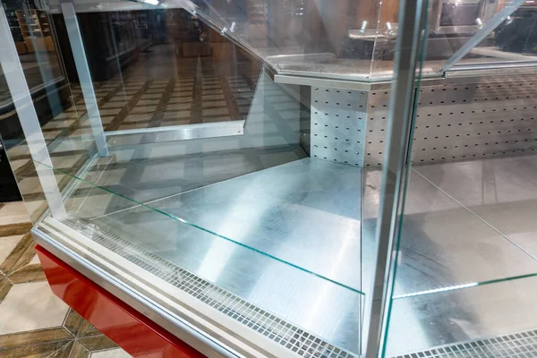 Empty shelves in a supermarket amid the coronavirus pandemic. Shopping center closure. Empty commercial fridges at grocery store. Sold out frozen food section
