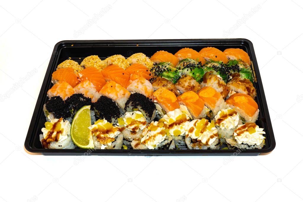 Sushi set with rolls philadelphia, california, bonito, tuna, sesame, black tobico, chuka salad, prawns and cream cheese lie in black box for delivery. Japan kitchen, european sushi rolls