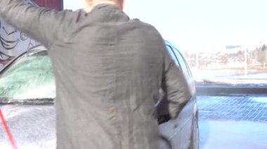 Yüksek basınçlı çamaşır makinesi. Araba yıkama ve temizlik. Bir adam elle araba yıkamada tek başına araba yıkar.