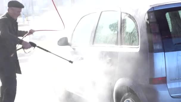 Auto wassen en detailleren. Een man wast een auto in z 'n eentje bij een handmatige wasstraat. — Stockvideo