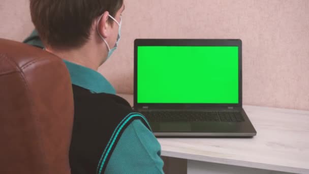 Ein Mann macht Aufwärmübungen, während er am Laptop sitzt, per Videoanruf in einer Schutzmaske, chromokey — Stockvideo