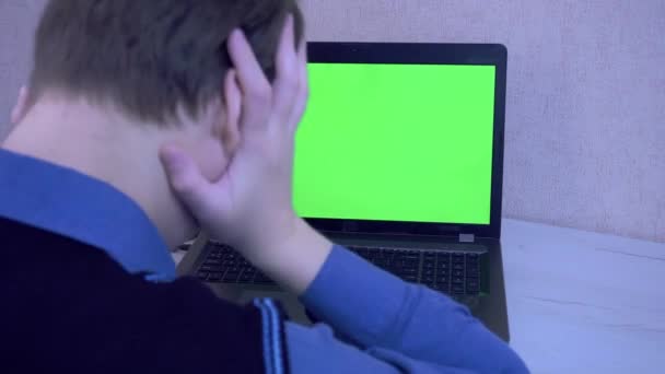 Un tipo emocionalmente enojado por una conexión remota en una videoconferencia y golpea sus puños contra una computadora portátil, pantalla verde — Vídeos de Stock