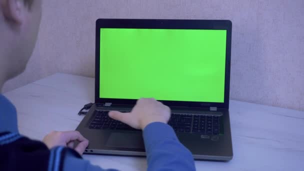 En man hälsar sina kollegor med video som kallar på en bärbar dator och påminner honom att sätta på sig en skyddande ansiktsmask, en grön bildskärm — Stockvideo