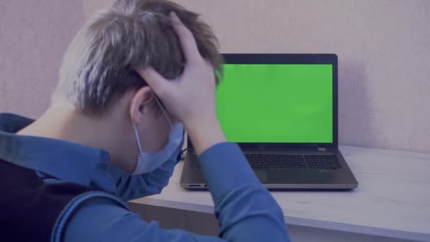 Chlápek v ochranné masce je emocionálně naštvaný kvůli dálkovému spojení na videokonferenci a buší pěstmi do notebooku, zelené obrazovky — Stock video