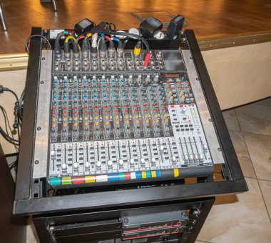 Konser salonunda bağlı bujiler ve ses aygıtları olan ses mühendisi konsolu