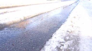 Akarsu asfaltta akar bahar güneşinin altında bir araba tekdüzeliğinde.