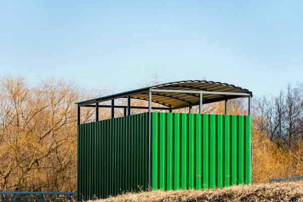 En busshållplats från en grön metallprofil en vårdag — Stockfoto