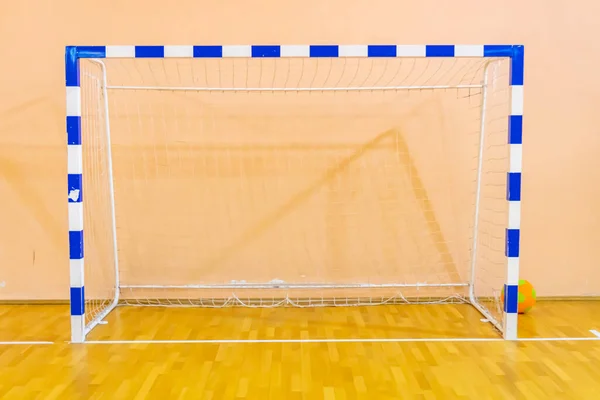 Football goal at a sports center, a sports hall with a wooden floor and a football sash