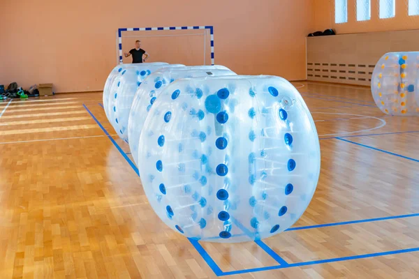 Färgglada stötfångare boll bubbla ballonger i sporthallen. Utrustning för team bygga sport spel som heter stötfångare boll eller bubbla boll. Zorbfotboll. — Stockfoto
