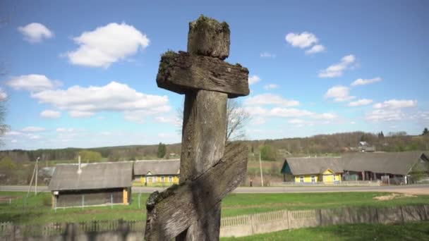 Древний деревянный христианский православный крест на древнем кладбище на окраине села на фоне облаков — стоковое видео