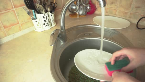 Καθαρισμός της κουζίνας, πλύσιμο πιάτων στο νεροχύτη της κουζίνας, ξέπλυμα πιάτων μετά το φαγητό — Αρχείο Βίντεο