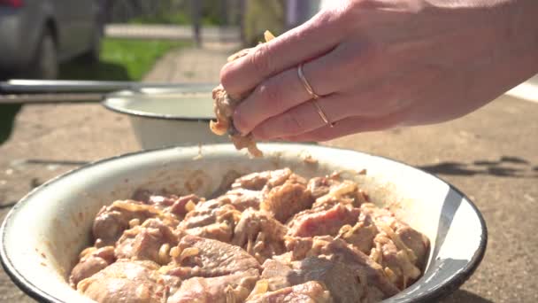 La jeune fille met la viande marinée sur les brochettes pour la cuisson sur le gril, l'ouverture de la saison du barbecue — Video