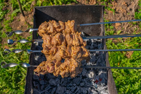 Gegrilltes Fleisch auf Spießen, gebratene Spieße auf Spießen auf rostigen Kohlenbecken — Stockfoto