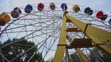 Bir lunaparkta Sovyet dönme dolabı, alt manzara. İnsanlar eski bir dönme dolaba binmekten hoşlanırlar. Gri gökyüzüne karşı bir lunaparkta.