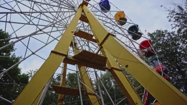 Roda gigante soviética em um parque de diversões, vista de fundo. Base com entrada de uma roda gigante em movimento no parque de atração — Vídeo de Stock