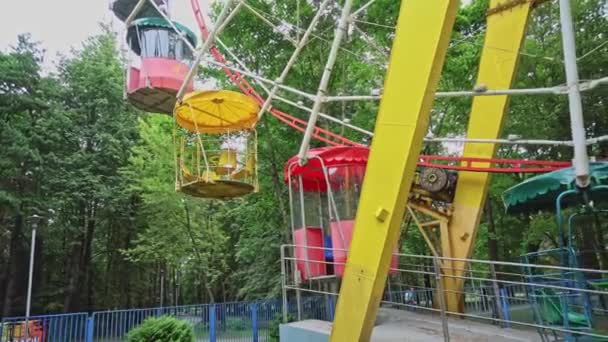 Eski bir Sovyet dönme dolabının kokpitine binmek, bir lunaparkta, sol tarafta. Çekim parkında hareket eden dönme dolap girişi olan üs. — Stok video