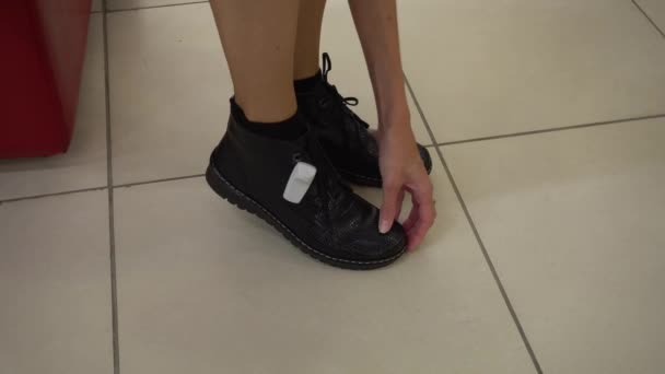 Fille essayer de nouvelles chaussures dans un magasin de chaussures, laçage de nouvelles chaussures, salle d'essayage de chaussures — Video