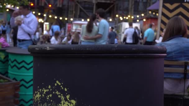 Folk går på semester på kvällen, ägnar sig åt promenader. Konst utrymme med människor som går ur fokus — Stockvideo