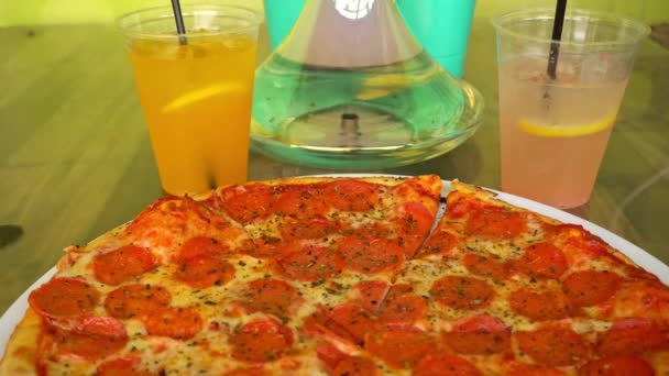 Hookah wrze na tle gorącej pizzy pepperoni i świeżej lemoniady w ulicznej kawiarni — Wideo stockowe