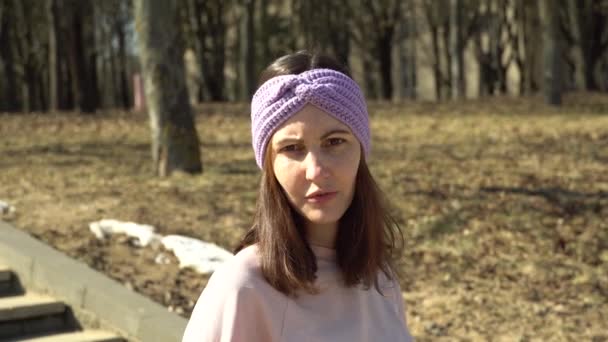 Une fille dans un turban tricoté parle de fils et d'aiguilles et souriant — Video