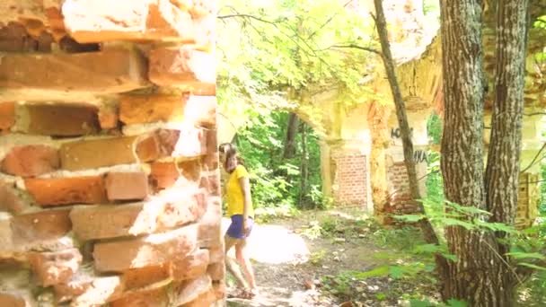 Menina blogueira viajante para lugares abandonados leva um fluxo direto de ruínas antigas, viagens blogueiro córregos das ruínas — Vídeo de Stock