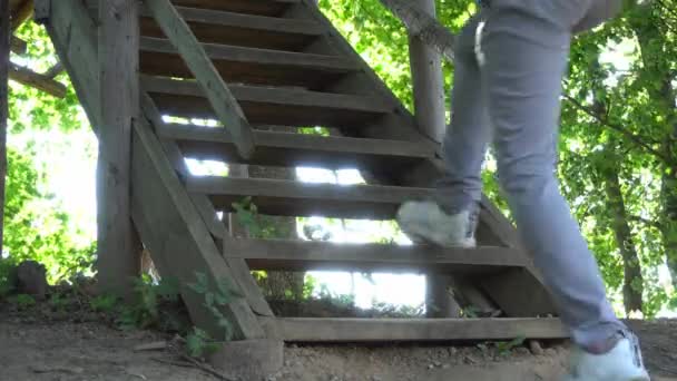 Guy piedi salire gradini di legno per casa sull'albero, rustico casa sull'albero fatta in casa per i bambini — Video Stock