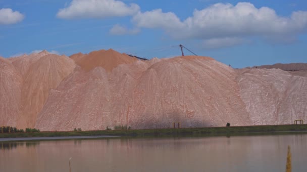 Mining industry and technical reservoir. Telestacker and potash waste heaps, extraction of salt and potash fertilizers in a quarry and processing of ore — Stock Video