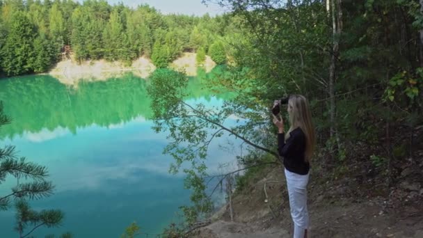 Egy lány lelő egy tájat egy elárasztott krétakő hátterében, túlburjánzott krétakőfejtőkkel. — Stock videók