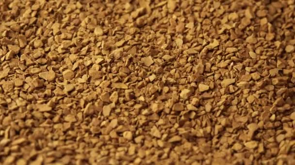 Granules of instant coffee sprinkled on a plate close-up spinning as a backdground for a coffee shop, granulated coffee commercial, morning cheer — Stock Video