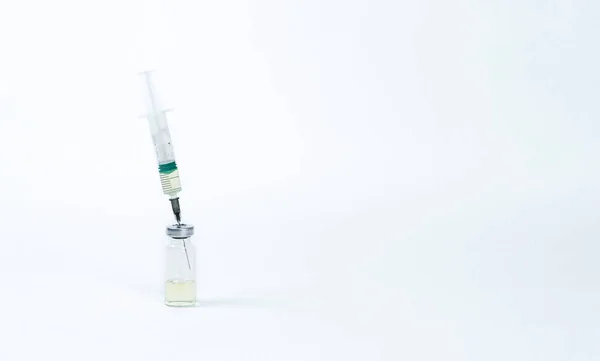 Auf weißem Hintergrund wird eine Spritze in ein Fläschchen mit Impfstoff eingeführt. — Stockfoto