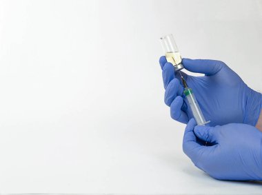 Eldivenli erkekler şişeye yerleştirilmiş bir şırınga tutuyorlar ve aşıyı yazıyorlar.