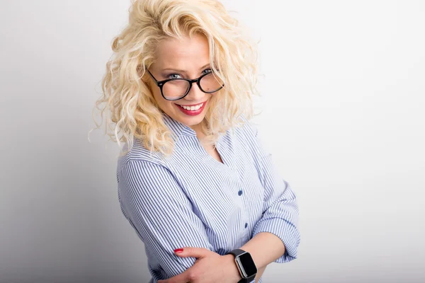 Coqueta y divertida mujer mirando por encima de sus gafas — Foto de Stock