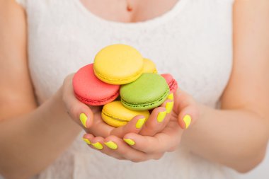 Macaroons her iki elinde tutan kadın