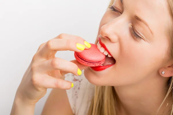 Šťastná žena stravovací růžové zákusek makarónek — Stock fotografie