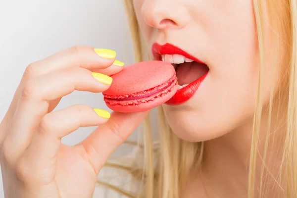 Žena jíst červené zákusek makarónek — Stock fotografie