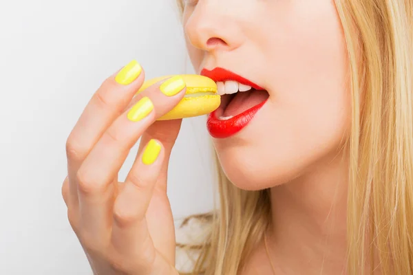 Žena jíst žluté zákusek makarónek — Stock fotografie