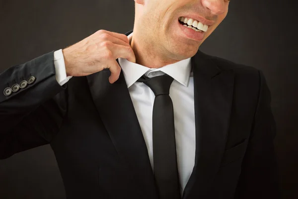 Homem de negócios puxando sua camisa do pescoço — Fotografia de Stock