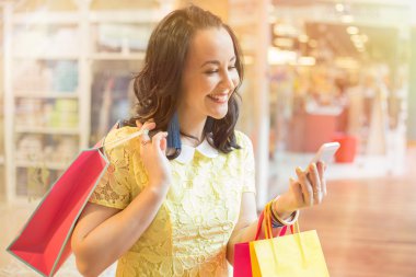 Alışveriş yaparken Smartphone kullanan kadın