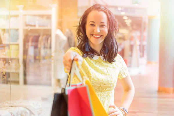 Mulher com mão estendida segurando sacos de compras — Fotografia de Stock