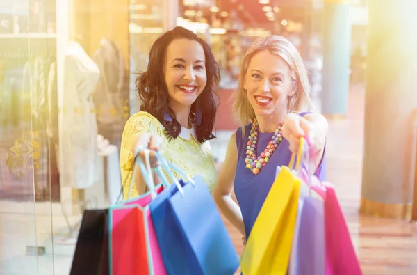 Two friends showing their shopping bags — Stock Photo, Image